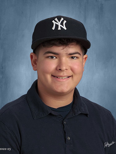 Teenage boy wearing a dark polo shirt and a New York Yankees cap