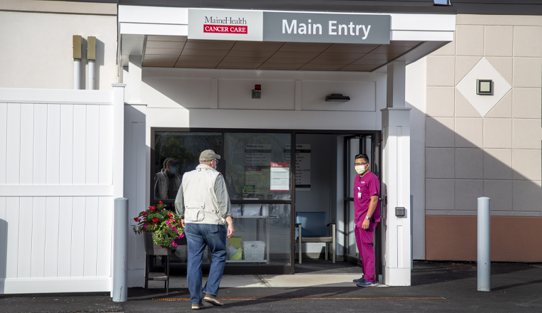 A patient walking in through the main entrance of the MaineHealth Cancer Care clinic 