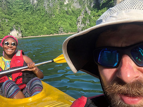 Close-up of a man's face with a woman in a kayak behind him