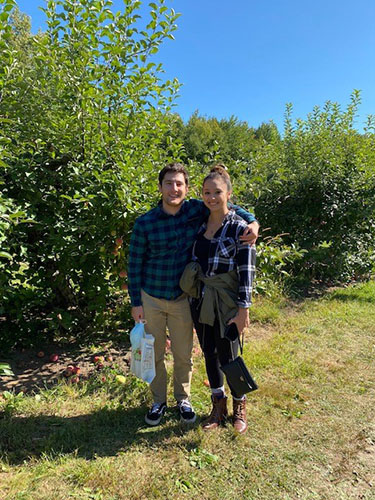Man and woman standing together in an apple orchard