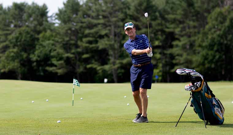 Spine patient John Ernst swings his golf club