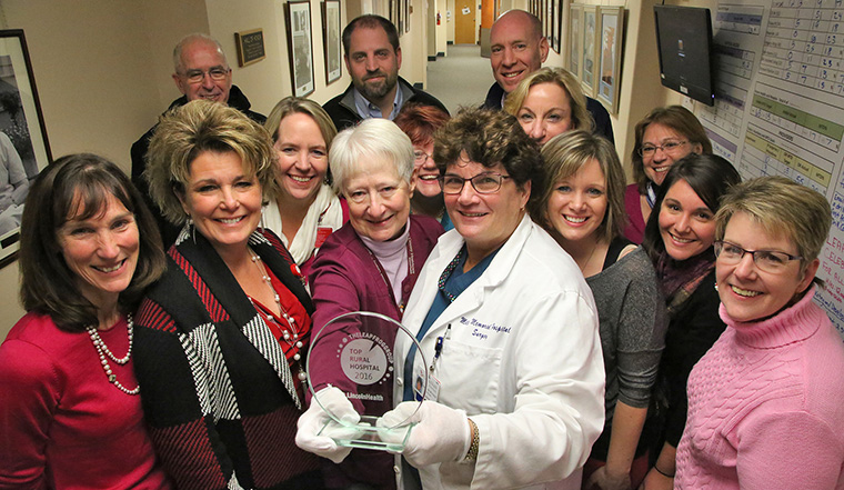 Group of employees posing with an award