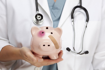 a doctor holding a piggy bank