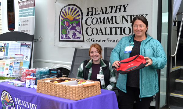 Two women standing at the Healthy Community Coalition booth at the Farmington Fair