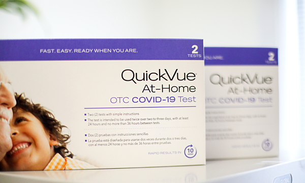 Two boxes of QuickVue At-Home COVID-19 tests sitting on a countertop