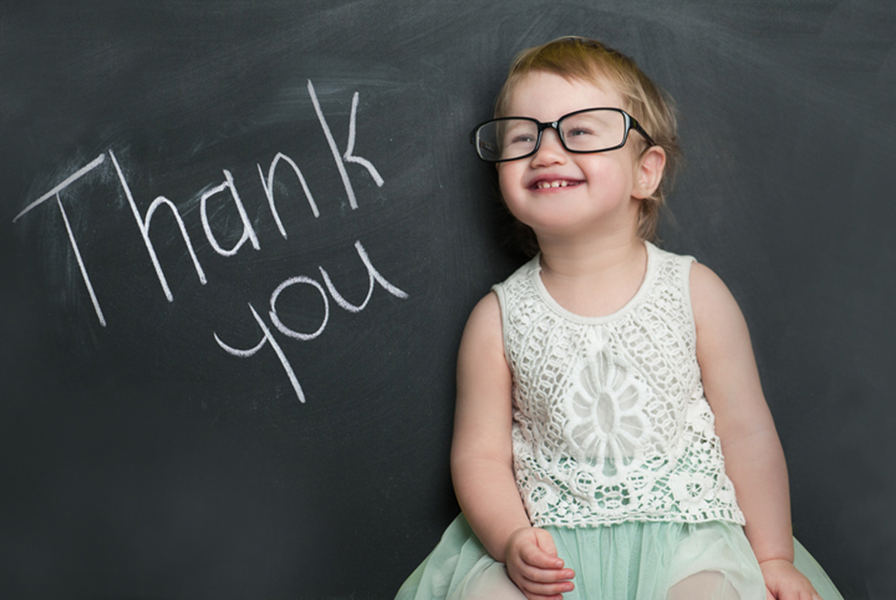Young girl sitting near the words "Thank you"